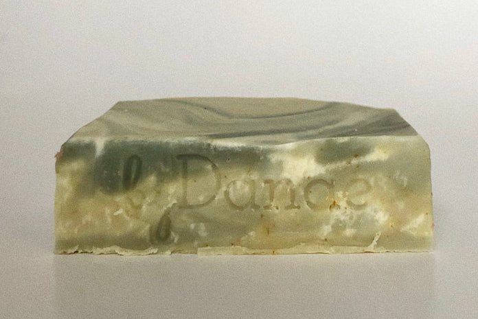 Bar of soap with various shades of green swirls on a white background representing the parsley soap byDanae
